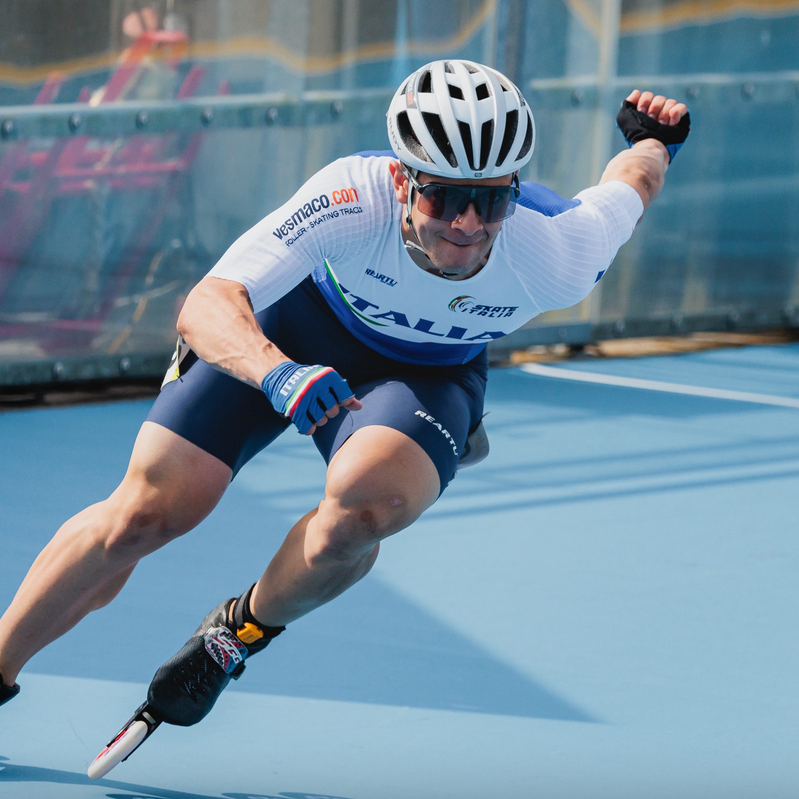 Alessio Piergigli crossing the finish line, arms open, wearing the Italy national speed skating jersey